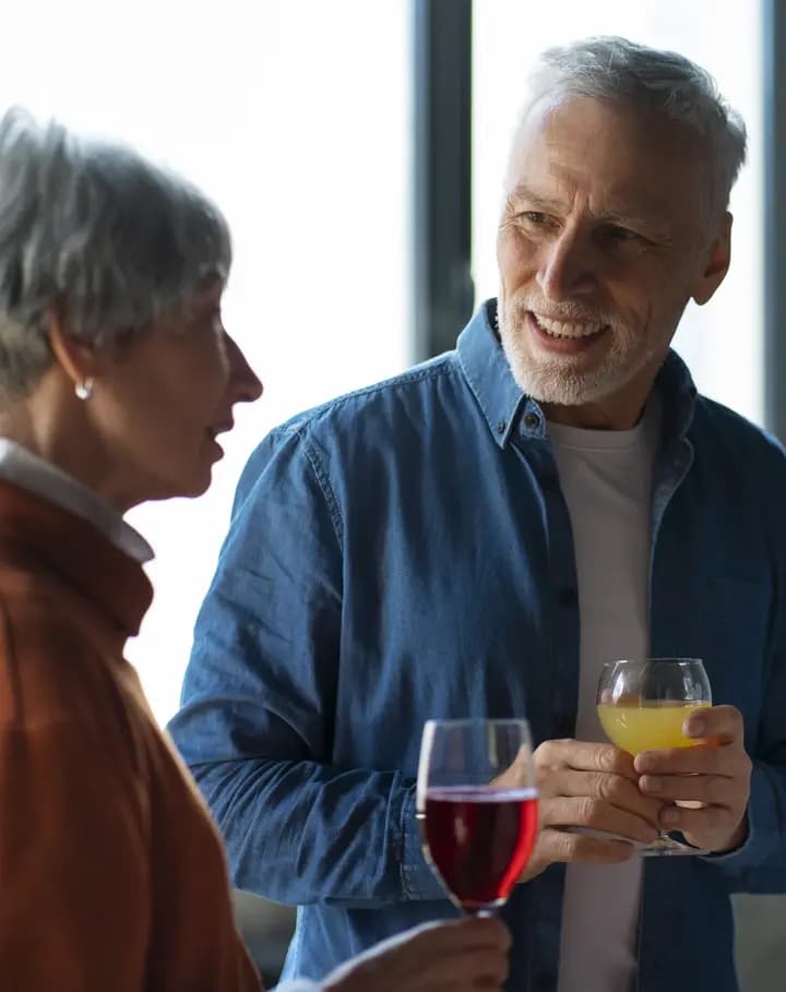 Two guests talking over drinks at a reception.